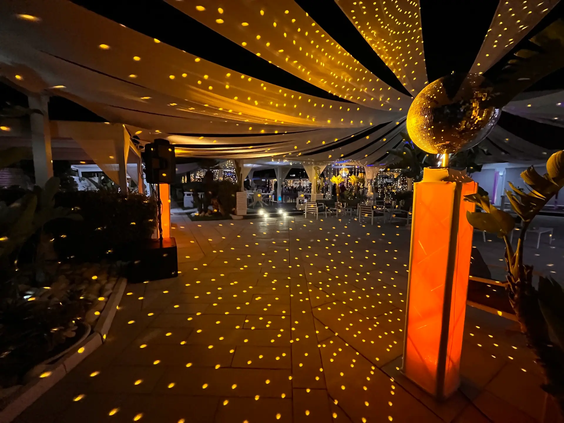 Dehors di una location allestito da FC Service con sfera specchiata dorata e punti di luce su tutta la pavimentazione