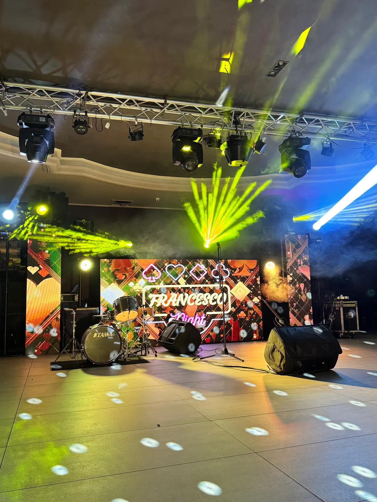 Sala allestita con truss aereo, teste mobili accese, ledwall e palco pronti prima dell'evento