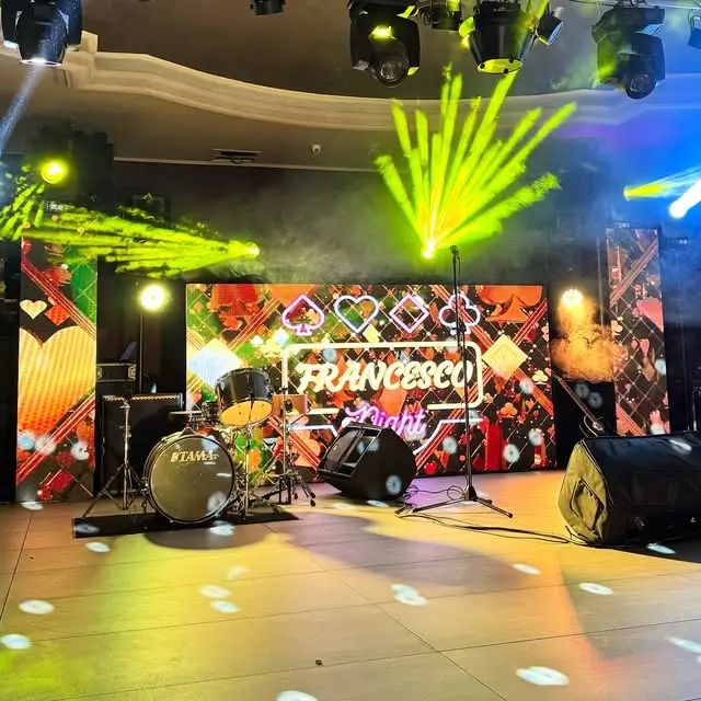 Palco allestito con batteria, ledwall personalizzato e fasci di luce gialli